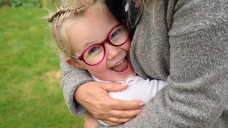 A child enjoying a hug with a grown up